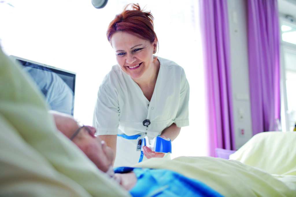 Frau lächelt hinunter auf Patienten
